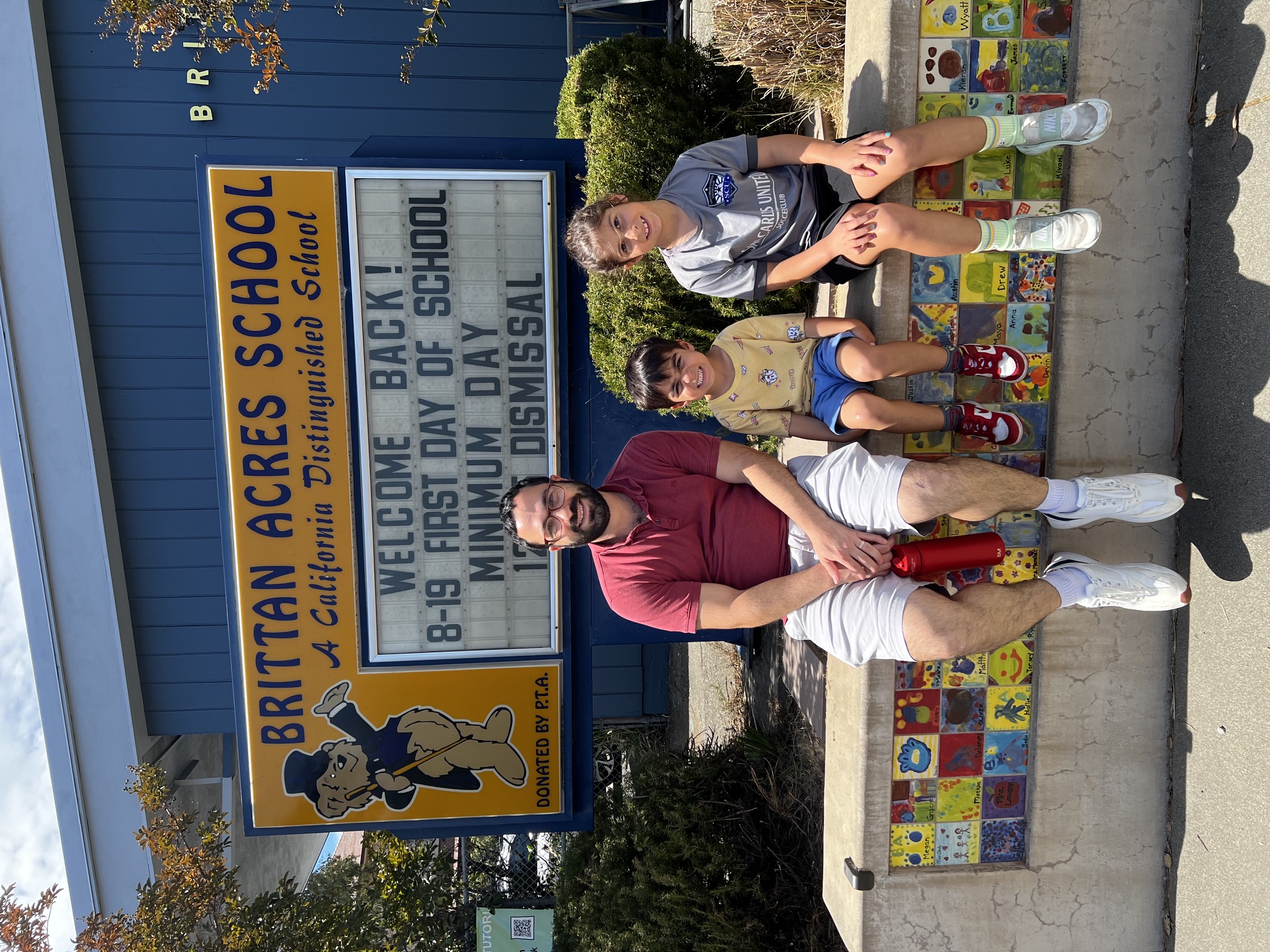 Brittan Acres School sign with a family on the first day of school