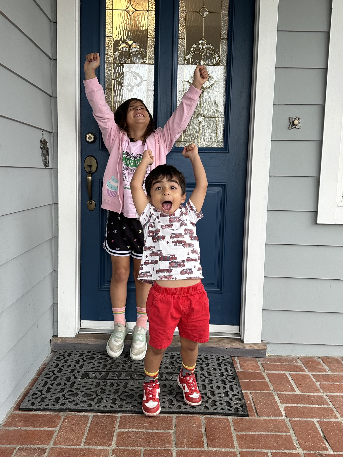 Two children celebrating the first day of school at home